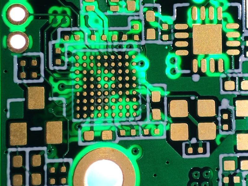 Macro view of a dense BGA footprint and via-pad array on a green printed circuit board